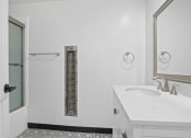 Thumbnail 7 of 11 - a white bathroom with a sink and a shower