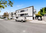 Thumbnail 2 of 4 - a white van parked in front of a white building