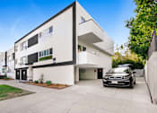 Thumbnail 4 of 4 - a white and black house with a car parked in front of it