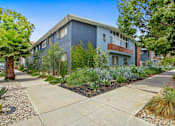 Thumbnail 3 of 3 - A modern apartment building with a well-maintained garden in front.