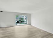 Thumbnail 1 of 10 - A room with a window and wooden flooring.