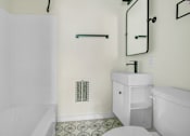 Thumbnail 7 of 10 - A white bathroom with a toilet, sink, and shower.