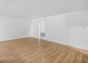 Thumbnail 1 of 17 - an empty living room with white walls and wood floors
