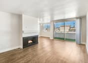 Thumbnail 1 of 13 - A living room with a fireplace and sliding glass doors.