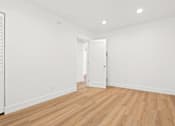 Thumbnail 5 of 28 - A room with wooden floors and white walls.