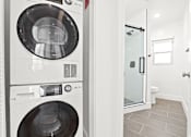 Thumbnail 6 of 28 - A white washing machine and dryer in a laundry room.