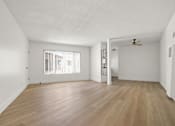 Thumbnail 1 of 9 - A room with wooden floors and a ceiling fan.