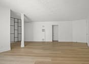 Thumbnail 2 of 9 - A room with wooden flooring and white walls.