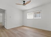 Thumbnail 6 of 9 - A room with a ceiling fan and a window with blinds.