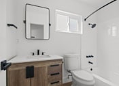 Thumbnail 7 of 9 - A white bathroom with a sink, toilet, and bathtub.
