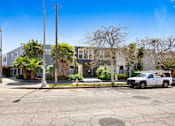 Thumbnail 9 of 9 - A street view of a residential area with a white car parked on the side of the road.