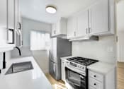 Thumbnail 19 of 28 - A modern kitchen with white cabinets and appliances.