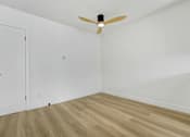 Thumbnail 21 of 28 - A room with a ceiling fan and wooden flooring.