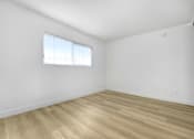Thumbnail 22 of 28 - A room with wooden flooring and a window with blinds.