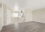 Thumbnail 10 of 28 - A spacious room with light wood flooring and white walls.