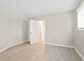 Thumbnail 14 of 28 - A room with a white door and wooden floor.