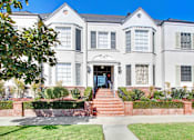 Thumbnail 1 of 3 - A white two-story house with a red brick staircase leading to the front door.