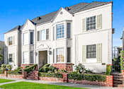 Thumbnail 3 of 3 - A white two-story house with a red brick wall in front.