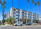 Thumbnail 1 of 5 - A blue and white building with a USPS van parked in front.