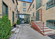 Thumbnail 2 of 39 - A building with a green door and a brick wall.