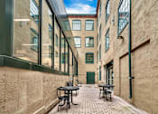 Thumbnail 20 of 39 - A narrow alley with tables and chairs on either side.