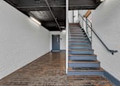 Thumbnail 23 of 39 - A staircase with a metal railing and wooden steps.