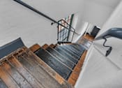 Thumbnail 34 of 39 - A staircase with a metal railing and wooden steps.