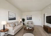 Thumbnail 1 of 25 - A living room with a white couch, a coffee table, and a television.