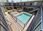 Thumbnail 9 of 25 - A pool in a courtyard surrounded by a fence.