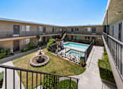 Thumbnail 12 of 25 - A balcony overlooks a courtyard with a fountain and pool.