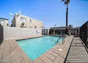 Thumbnail 6 of 17 - A pool surrounded by a black fence and concrete walkway.