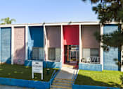 Thumbnail 2 of 7 - A building with a blue, pink and red exterior.