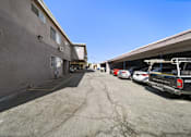 Thumbnail 5 of 7 - A parking lot with several cars and a building on the left.