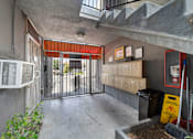 Thumbnail 14 of 21 - A concrete room with a red awning and a metal gate.