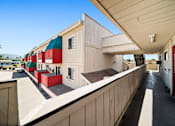 Thumbnail 14 of 17 - A long building with red and green doors.
