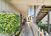 Thumbnail 5 of 17 - A long, narrow hallway with a white picket fence and a staircase on the right.