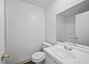Thumbnail 25 of 25 - A white bathroom with a toilet, sink and mirror.