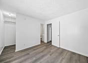 Thumbnail 20 of 25 - A room with white walls and a wooden floor.