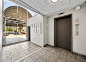 Thumbnail 14 of 19 - A hallway with a brown elevator and a white wall.