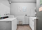 Thumbnail 17 of 19 - A laundry room with a washer and dryer.