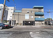Thumbnail 18 of 18 - A car is parked in front of a building with a blue awning.