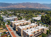 Thumbnail 4 of 7 - A view of a residential area with apartment buildings and a mountain range in the background.