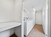 Thumbnail 6 of 7 - A white laundry room with a washer and dryer.
