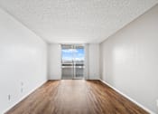 Thumbnail 14 of 27 - A room with wooden floors and white walls.