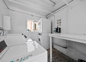 Thumbnail 10 of 10 - A white washing machine is in a room with a white wall.