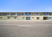 Thumbnail 3 of 10 - A building with a blue door and windows.