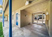 Thumbnail 7 of 10 - A blue door is on the left side of a building.