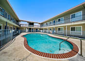 Thumbnail 8 of 10 - A swimming pool in a courtyard surrounded by apartment buildings.