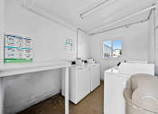 Thumbnail 9 of 10 - A white laundry room with a washer and dryer.
