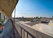 Thumbnail 10 of 17 - A parking lot with cars and a building in the background.